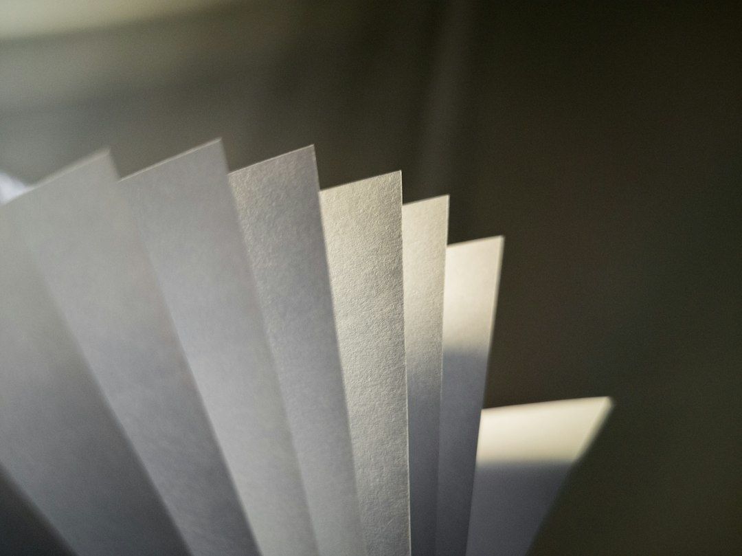 Fächerförmig angeordnete weiße Papierblätter im wechselnden Licht