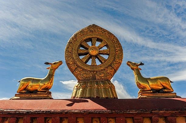 Goldenes Rad mit zwei liegenden Hirschen vor blauem Himmel